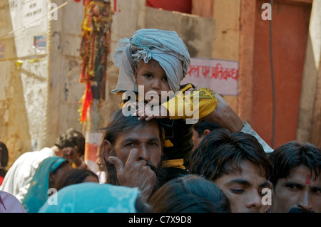 Kleiner Junge auf Väter Schultern Queueing, Tempel bei Kaila Devi Rajasthan Indien zu besuchen Stockfoto