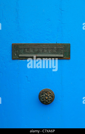 Nahaufnahme einer hellen blauen Tür mit einem gealterten Metall Briefkasten in Valletta, Malta. Stockfoto