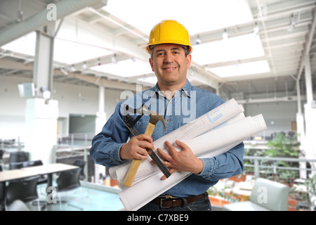 Mann, Pläne und Werkzeuge in einem modernen Gebäude Stockfoto