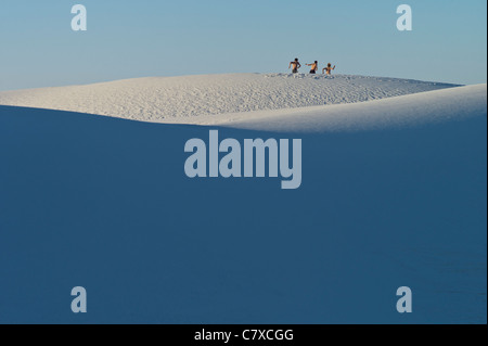 Drei junge Leute, die quer über White Sands National Monument, New Mexico, USA Stockfoto
