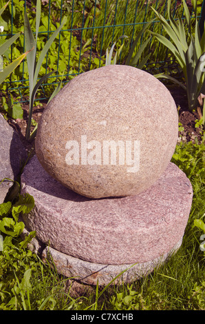 Einige Mühlsteine aufeinander und Stein an der Spitze. Stockfoto