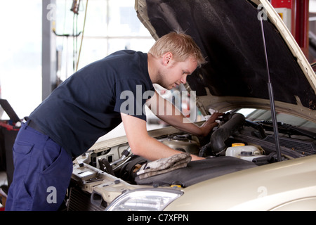 Einen jungen Mechaniker unter der Motorhaube eines Autos Reparaturen Stockfoto
