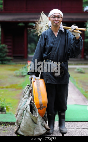 Zen-buddhistischen Mönch auf Arbeit - Reinigung oder Gartenarbeit - Aufgaben im Tempelgelände, traditionellen Roben tragen. Stockfoto