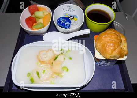 Airline-Essen in der Economy Class: Kabeljau in Sauce, Croissants, Obst, Salat und Kaffee; während des Fluges Essen; Essen auf einer Ebene; Flugzeug-Essen; Tablett Stockfoto