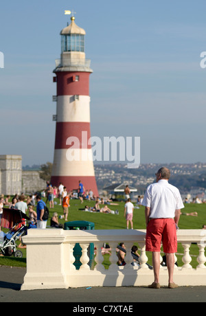 Mann in weißem Hemd und rote Shorts betrachten Smeatons Tower ehemaligen Leuchtturm auf Plymouth Hacke Devon UK Stockfoto