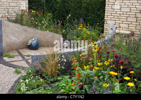 Kleine Cottage Innenhof städtischen Garten mit kreisförmigen Stein gepflasterten Pflaster und Kies Terrasse gemischt Sommer Grenze Grenzen Hecke Grenze Großbritannien Stockfoto