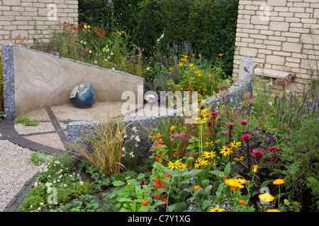 Kleine Cottage Innenhof städtischen Garten mit kreisförmigen Stein gepflasterten Pflaster und Kies Terrasse gemischt Sommer Grenze Grenzen Hecke Grenze Großbritannien Stockfoto