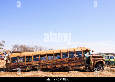 Alte rostige Schulbus teilweise eingestürzt auf Schrottplatz Stockfoto