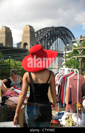 Eine stilvolle junge Frau in einem roten Hut Geschäfte für Bekleidung und Mode-Elemente auf einem freien Markt bei Kirribilli in Sydney Australia Stockfoto