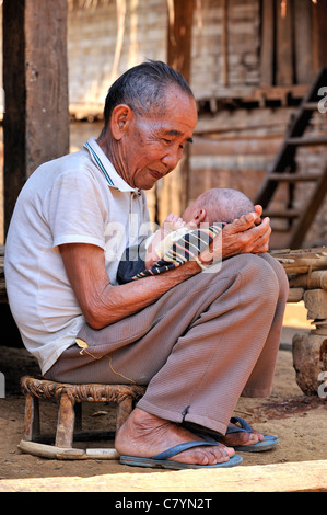Khmu Bergstämme, Alter Mann, hält ein Baby, Luang Prabang, Laos Stockfoto