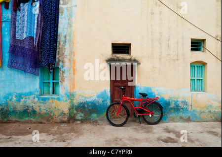 Red Indian Fahrrad gelehnt ein Haus in der indischen Straße. Puttaparthi, Andhra Pradesh, Indien Stockfoto