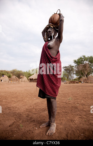 Mursi-Frau mit Wasserkrug auf Kopf, Jinka, Omo-Tal in Äthiopien, Afrika Stockfoto