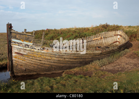 Ein verlassenes altes Fischerboot auf den Salzwiesen in der Nähe von Blakeney Kai Norfolk UK Stockfoto