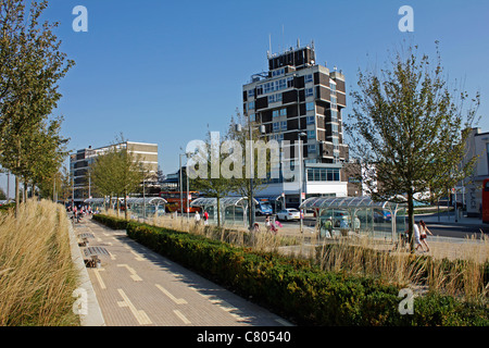 Ziergräser und Bäume schmücken die Straßen und erweichen die Umrisse der Bürogebäude in der Innenstadt von Corby Stockfoto