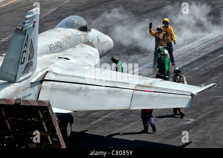 Cockpit-Besatzung positionieren eine F/A-18E Super Hornet in Startposition an Bord der USS Eisenhower. Stockfoto