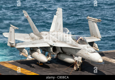 Ein US-Navy F/A - 18C Hornet festgebunden auf dem Flugdeck des Flugzeugträgers USS Nimitz. Stockfoto