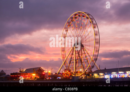 Ein Riesenrad auf dem South Pier in Blackpool bei Sonnenuntergang. Stockfoto