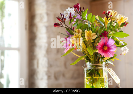 Farbfoto von einem frischen Blumenstrauß setzen innen auf dem Küchentisch an einem Frühlingsmorgen in Frankreich. Stockfoto