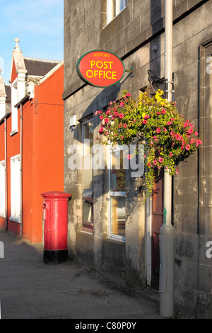 Rothes Post Office, Säule Box, ATM und hängenden Korb mit roten Blumen Stockfoto