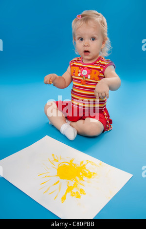 Kleine Künstler zeichnen malt die Sonne. Isolierte blau. Stockfoto