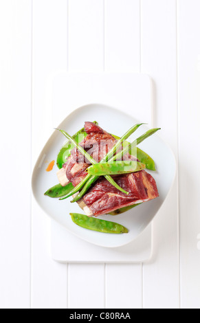 Geräucherte Schweinerippchen mit gebratene grüne Bohnen und Erbsen Stockfoto