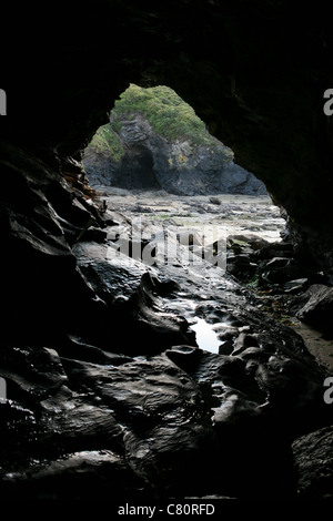 Blick von in einer Höhle auf der Suche nach der Eröffnung und auf eine weitere Höhle im Hintergrund. Stockfoto