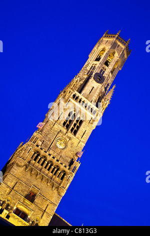 Die berühmte Ikone mittelalterliche Belfried oder Belfort mit Flutlicht in der Dämmerung in der Grote Markt, Brügge, Belgien Stockfoto