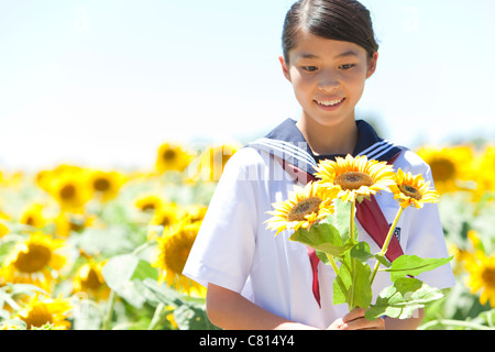 Schulmädchen Holding Bündel Sonnenblumen Stockfoto