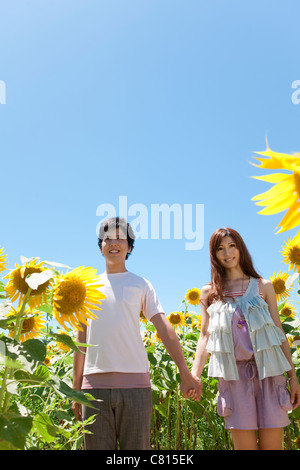 Junges Paar in Sonnenblumen Feld Stockfoto