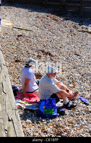 Pärchen entspannen sich während eines indischen Sommers im Oktober am Strand von West Wittering in der Nähe von Chichester, West Sussex, England, Großbritannien Stockfoto