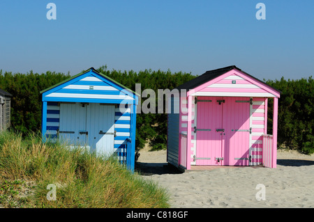 Einige der West Wittering's 156 Strandhütten - viele in Blau, Grün, Ocker und Rosa in einem privaten Strandgut, West Sussex, England, UK gemalt Stockfoto