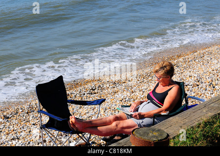 Frau, die sich während eines indischen Sommers im Oktober am Strand von West Wittering entspannt - West Sussex, England, Großbritannien Stockfoto