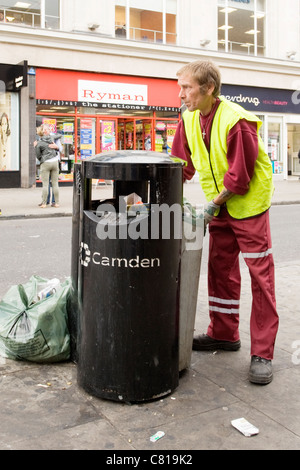 London Camden Lock Stables Markt RAT-Arbeiter in Uniform Hi Vis Jacke leeren Straße müll Abfall Mülleimer rauchen Stockfoto