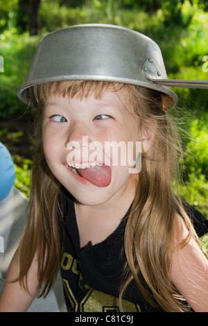 kleines Mädchen verzog das Gesicht und Zunge Stockfoto