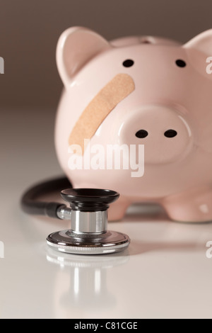 Sparschwein und Stethoskop mit selektiven Fokus auf einem abgestuften Hintergrund. Stockfoto