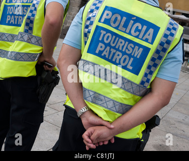 2 Tourismus Patrol Polizisten an der Uferpromenade in Porto, Portugal.  Sie tragen gelbe Jacken und Waffen zu tragen. Stockfoto