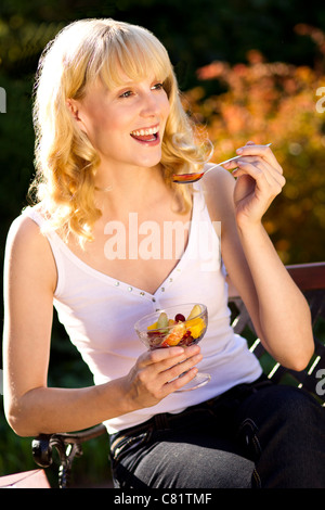 Frau Obst im Freien zu essen Stockfoto