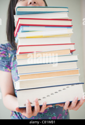 Koreanische Frau hält Stapel Bücher Stockfoto