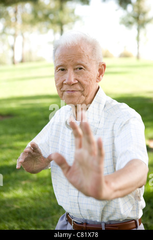 Hochrangige chinesische Mann tut Tai Chi im freien Stockfoto