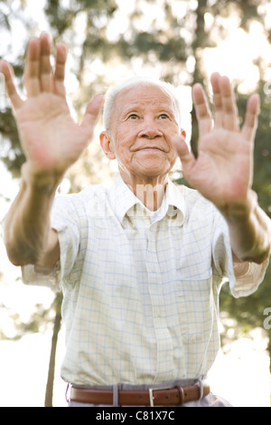 Hochrangige chinesische Mann tut Tai Chi im freien Stockfoto