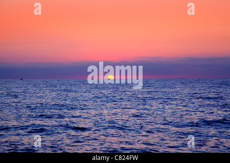 blaues Meer Sonnenaufgang mit Sonne im Horizont und Roter Himmel Stockfoto