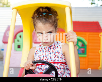 Böse Spielzeug Auto Fahrer Kinder Mädchen auf Spielplatz Stockfoto