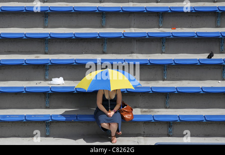 Einsamer Zuschauer sitzen unter Sonnenschirm bei den US Open 2011, Stockfoto