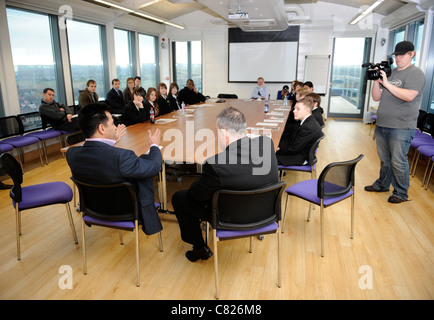 Kinder von Mitchell High School, Stoke-on-Trent in der Stadt des YMCA für ein Gespräch von Geschäftsmann Mo Chaudry (links) und Dart ch Stockfoto