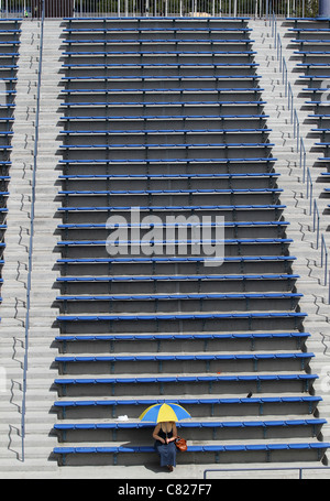 Einsamer Zuschauer sitzen unter Sonnenschirm bei den US Open 2011, Stockfoto