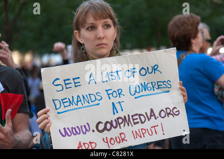 Eine Frau hält ein Schild in Zuccotti Park zeigt die Webseite eine Liste Anforderungen für Kongreß während der Occupy gefunden werden können Stockfoto