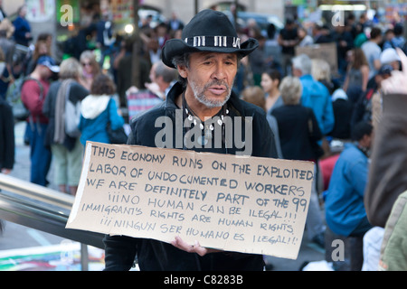 Ein Mann hält ein Protest Zeichen Besorgnis für undokumentierte Arbeiter und Immigranten während Demonstration Occupy Wall Street Stockfoto