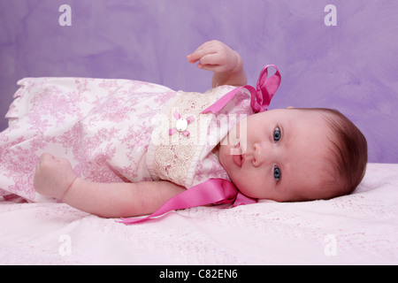 Nahaufnahme von drei Jahre altes Kind mit einem lila Hintergrund. Stockfoto