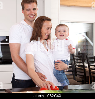 Glückliche Familie Zubereitung mit Vater gab der Mutter eine Umarmung Stockfoto