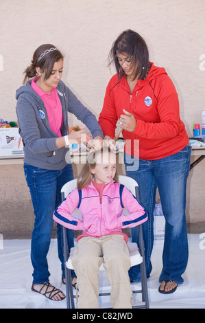 Ein junges Mädchen bekommt eine freakige Frisur an der Crazy Hair Salon, Art Block Party, Roswell, New Mexico. Stockfoto